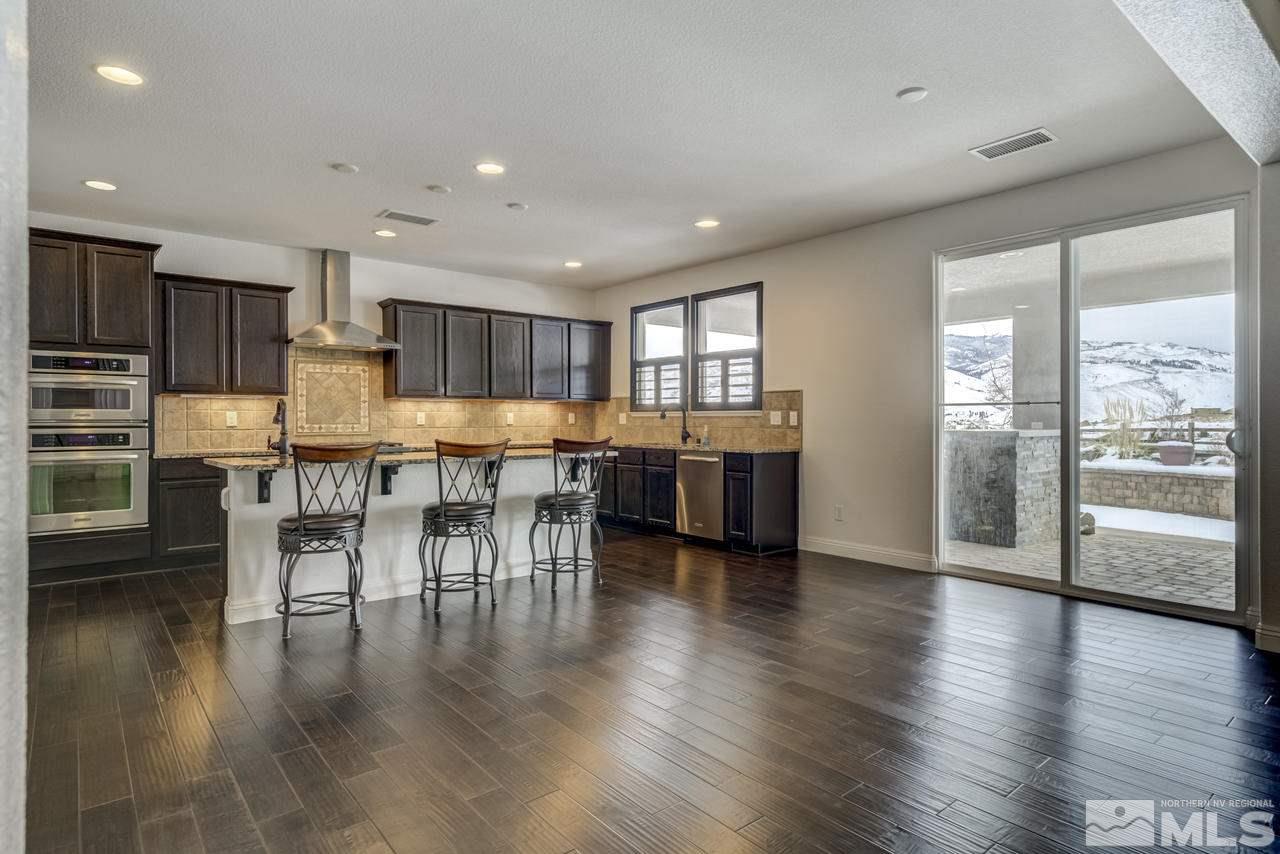 2105 Back Nine Trail Reno, NV 89523 - Photo 9 of 25 an open kitchen with white cabinets and stainless steel appliances
