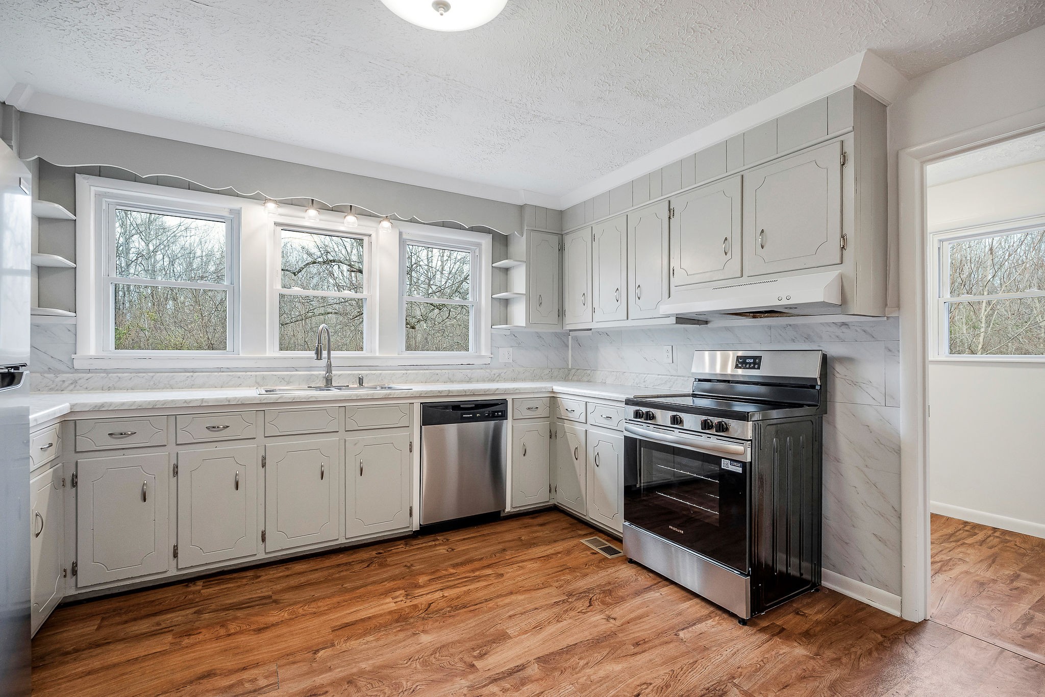 240 Blue Hill Road Woodbury, TN 37190 - Photo 5 of 17 a kitchen with granite countertop white cabinets a sink dishwasher and a stove with wooden floor
