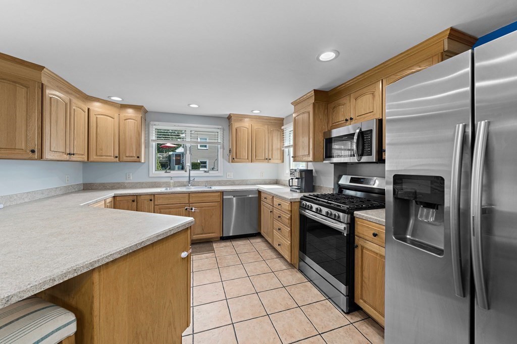 14 Edith Road Weymouth, MA 02189 - Photo 7 of 35 a kitchen with a sink a refrigerator and cabinets