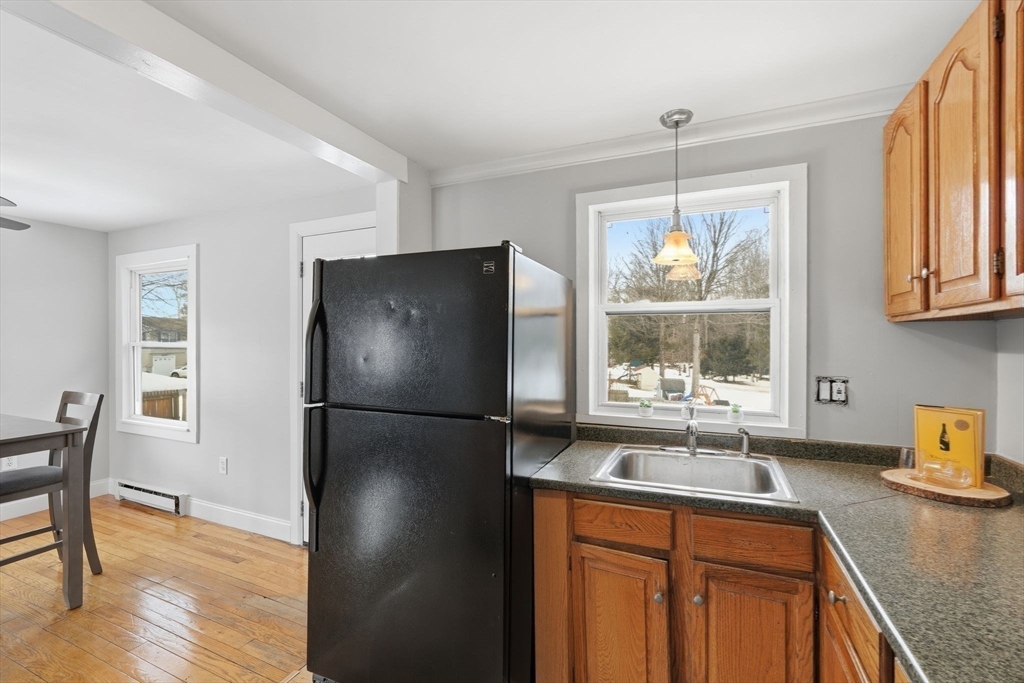 5 Marco Drive Pittsfield, MA 01201 - Photo 14 of 42 a kitchen with stainless steel appliances granite countertop a sink a refrigerator a stove a dining table and chairs with wooden floor