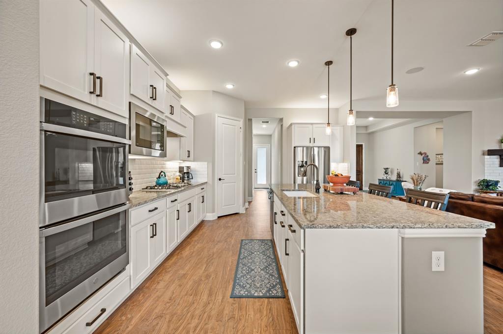 1226 Aster Place Haslet, TX 76052 - Photo 9 of 40 a kitchen with stainless steel appliances granite countertop a sink and refrigerator