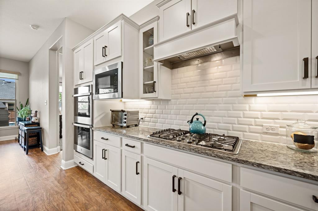 1226 Aster Place Haslet, TX 76052 - Photo 8 of 40 a kitchen with stainless steel appliances white cabinets a stove and a refrigerator