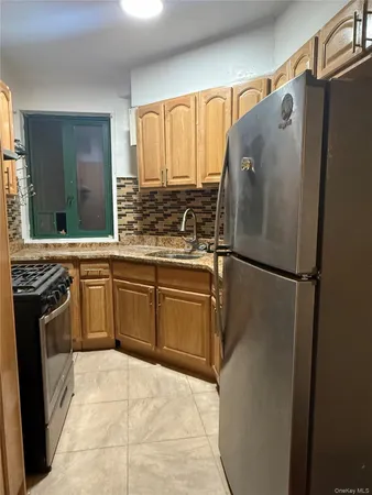 a kitchen with stainless steel appliances granite countertop a refrigerator sink and stove