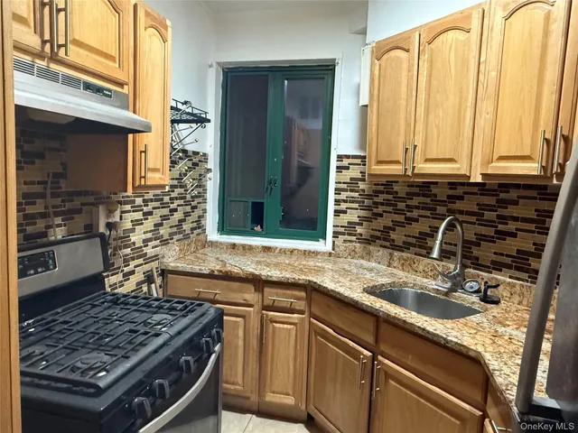 a kitchen with stainless steel appliances a sink stove and cabinets
