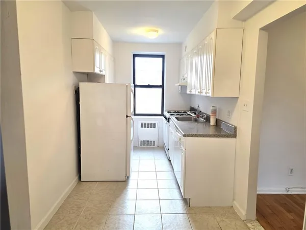a kitchen with a refrigerator a stove top oven and cabinets