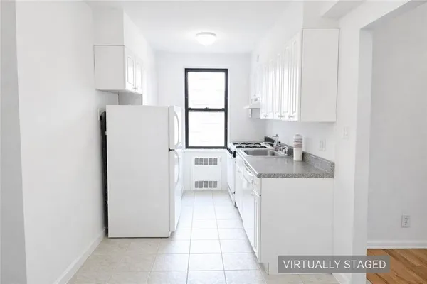 a kitchen with a sink a refrigerator and cabinets