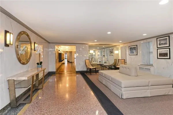 a living room with furniture a mirror and a chandelier