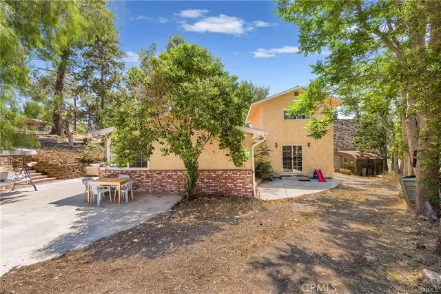 a view of a backyard with table and chairs and a fire pit