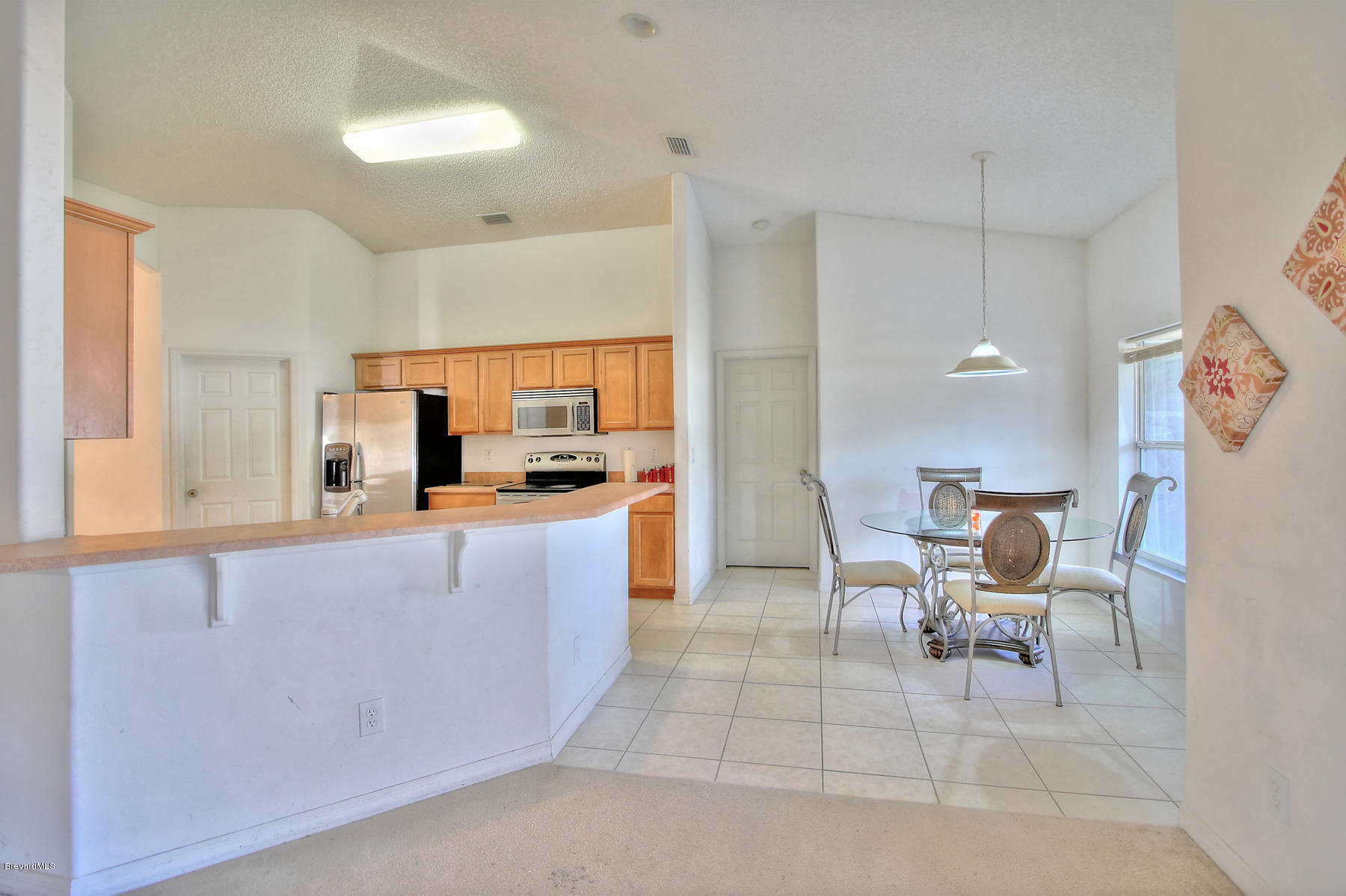 244 Abello Road Southeast Palm Bay, FL 32909 - Photo 12 of 23 a kitchen with a table chairs and a refrigerator