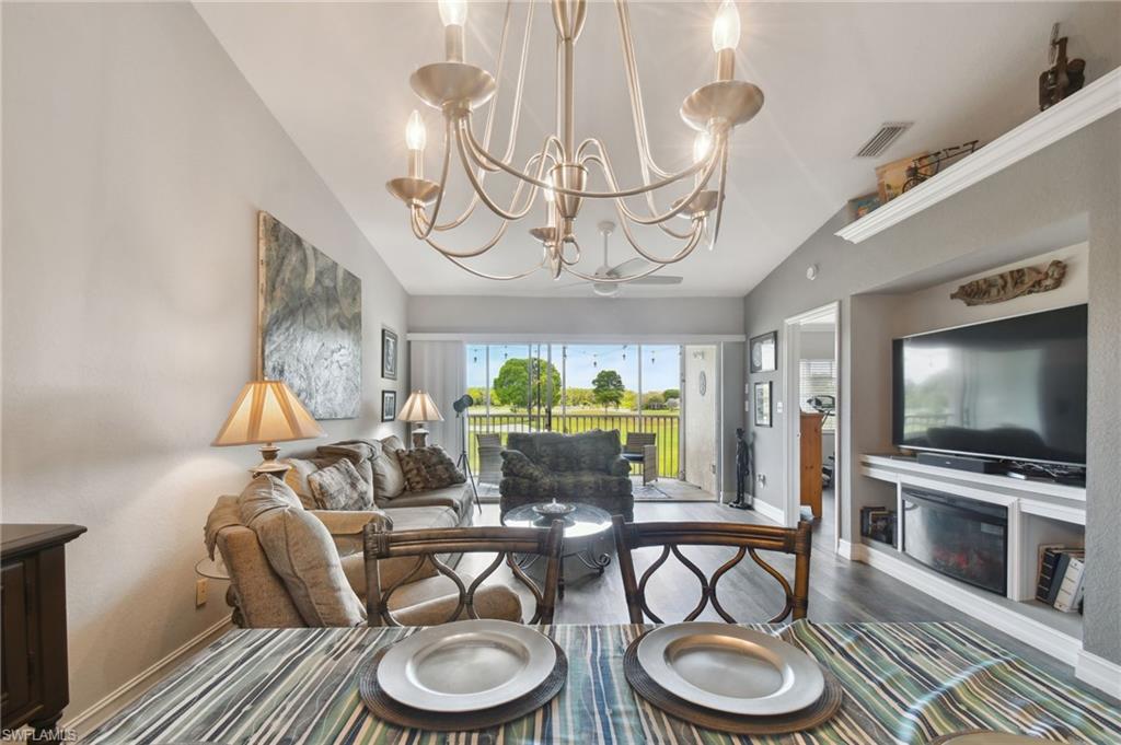 9165 Michael Circle, Unit 1002 Naples, FL 34113 - Photo 12 of 39 a dining room with furniture a chandelier and wooden floor