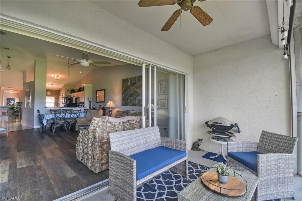9165 Michael Circle, Unit 1002 Naples, FL 34113 - Photo 14 of 39 a living room with furniture and a wooden floor