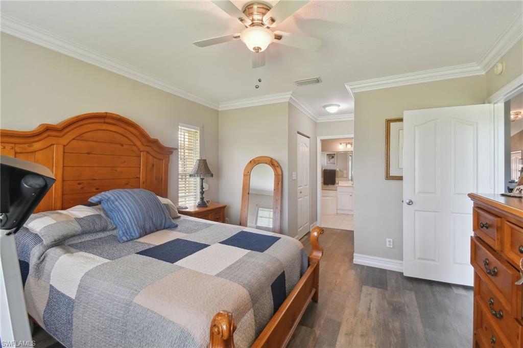 9165 Michael Circle, Unit 1002 Naples, FL 34113 - Photo 20 of 39 a bedroom with a bed and a dresser with mirror