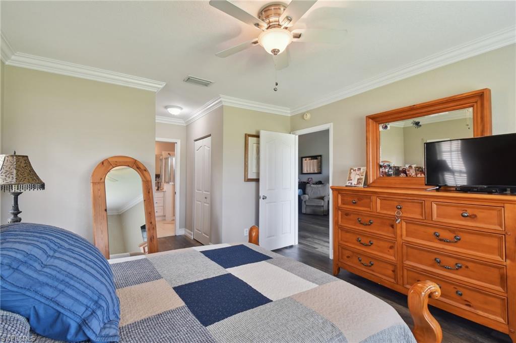 9165 Michael Circle, Unit 1002 Naples, FL 34113 - Photo 21 of 39 a bedroom with a bed and a dresser