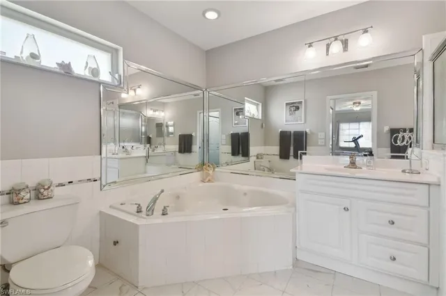 a bathroom with a bathtub sink mirror and toilet