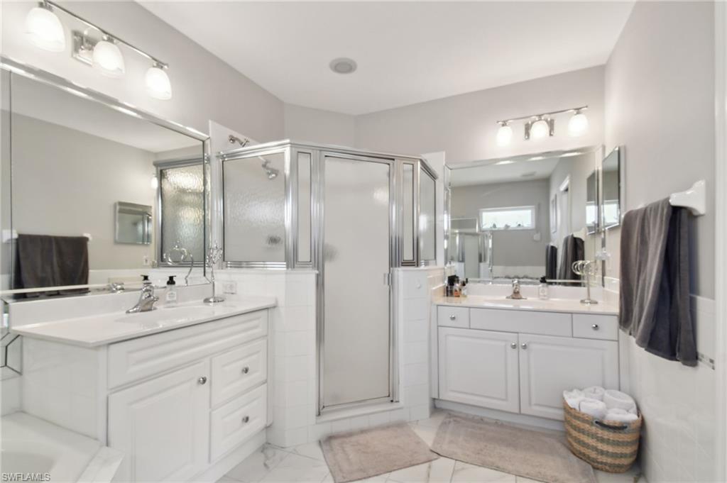 9165 Michael Circle, Unit 1002 Naples, FL 34113 - Photo 23 of 39 a bathroom with a sink double vanity and a mirror