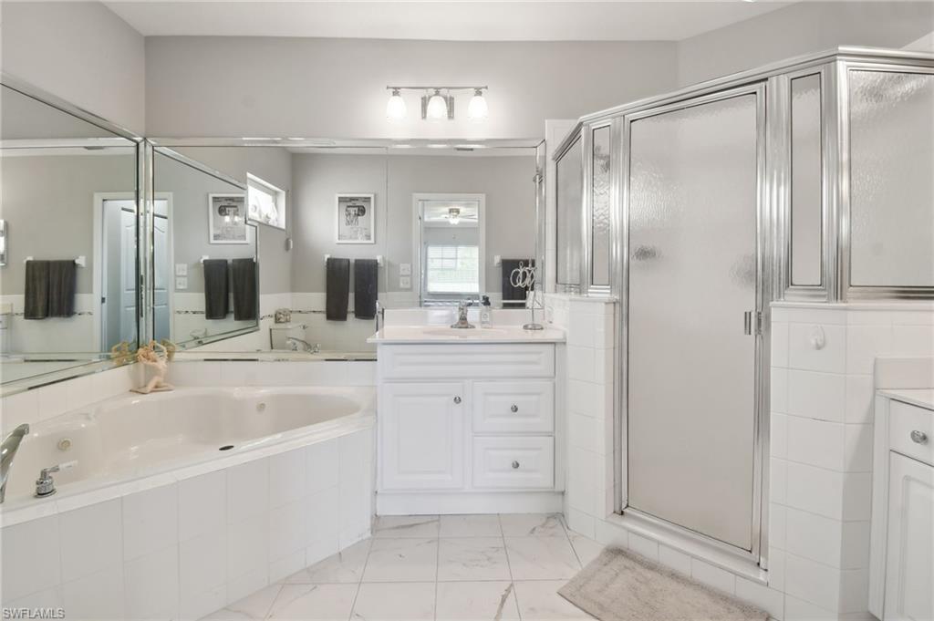 9165 Michael Circle, Unit 1002 Naples, FL 34113 - Photo 24 of 39 a bathroom with a double vanity sink mirror and bathtub