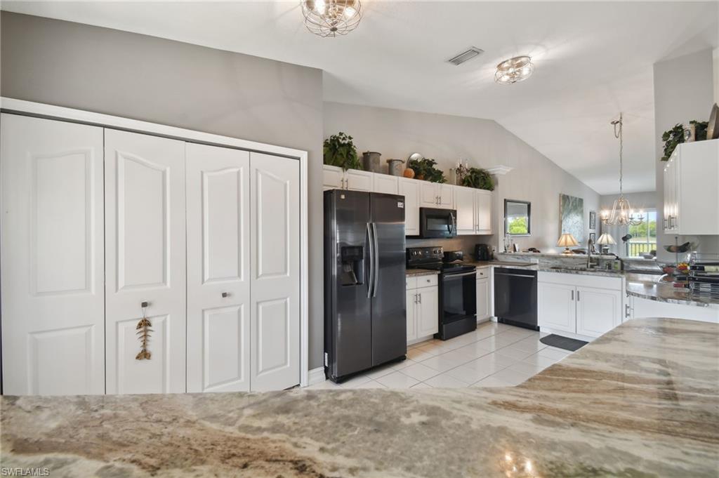 9165 Michael Circle, Unit 1002 Naples, FL 34113 - Photo 3 of 39 a kitchen with stainless steel appliances granite countertop a refrigerator and a sink