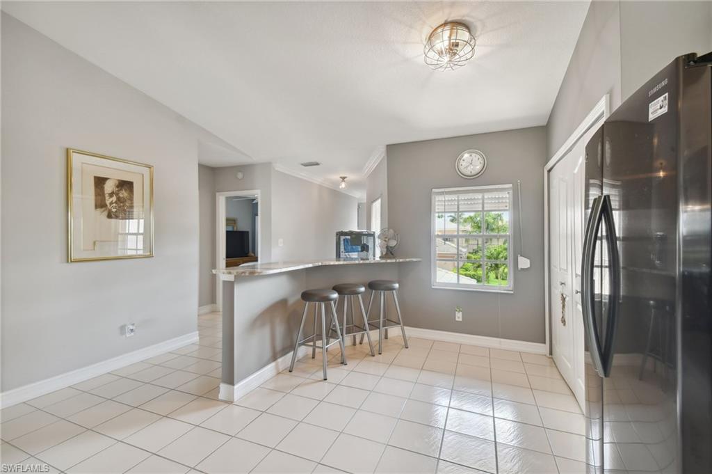 9165 Michael Circle, Unit 1002 Naples, FL 34113 - Photo 4 of 39 a view of kitchen with furniture and refrigerator