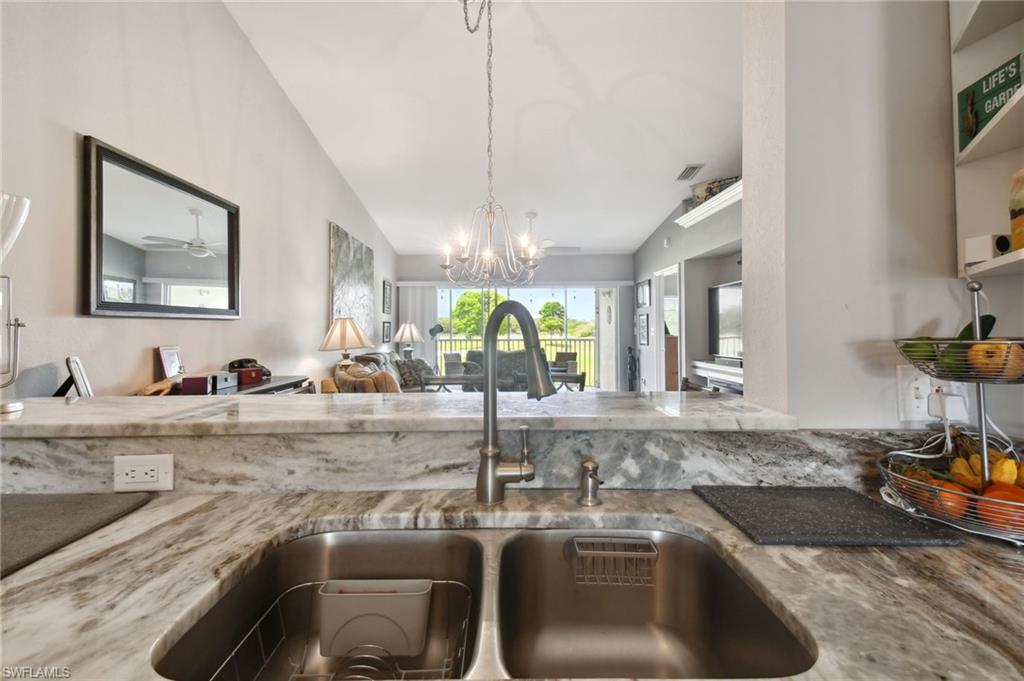 9165 Michael Circle, Unit 1002 Naples, FL 34113 - Photo 6 of 39 a kitchen with a sink and a refrigerator