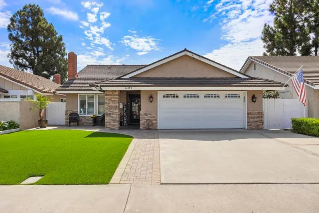 a front view of a house with yard and green space