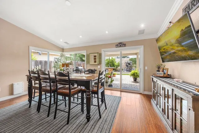 a view of a dining room and livingroom with furniture wooden floor and a rug