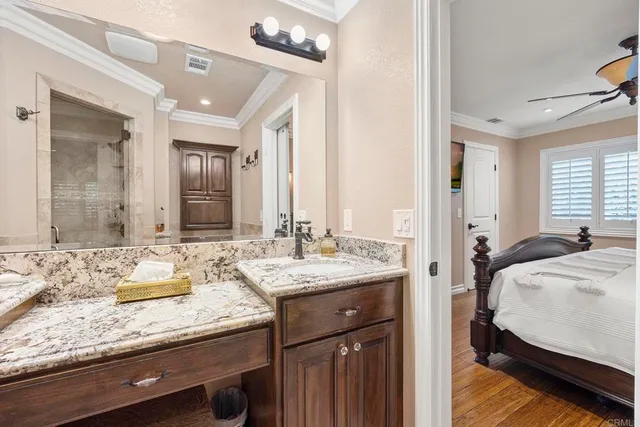a en suite bathroom with a granite countertop sink and a mirror