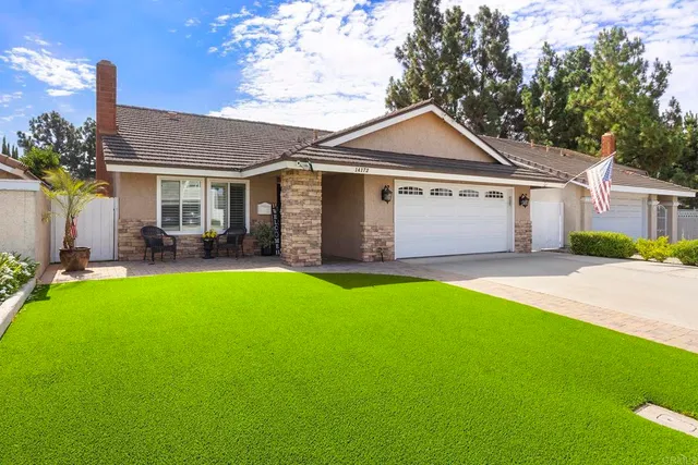 a front view of a house with a garden and yard