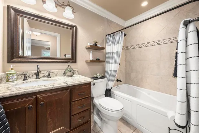 a bathroom with a granite countertop sink toilet a mirror a bathtub and shower