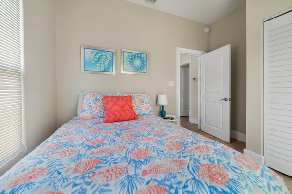 a bedroom with a bed and a lamp on dresser