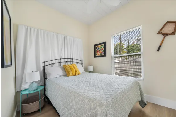 a bedroom with a bed and painting on the wall