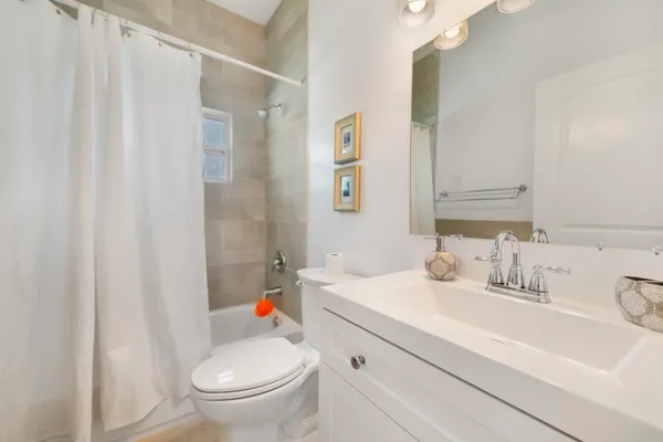 a bathroom with a sink a toilet and shower curtain