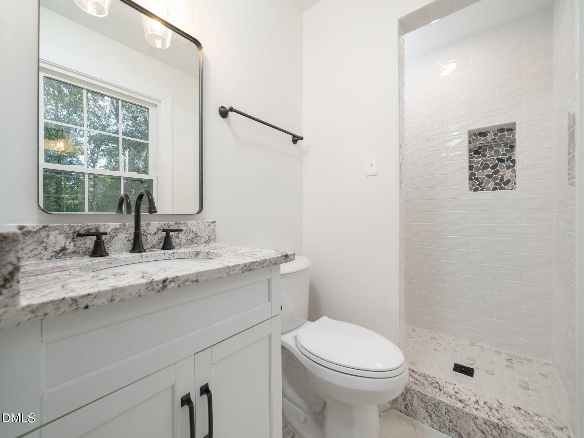 705 Villawood Court Raleigh, NC 27615 - Photo 23 of 31 The primary bath boasts a new vanity with granite counter tops, new toilet, mirror and lighting. Lovely tile surround completes the look of this elegant bath.