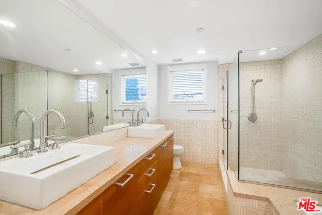 a bathroom with a double vanity sink mirror and shower