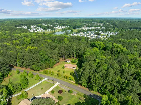 an aerial view of residential houses with outdoor space and trees