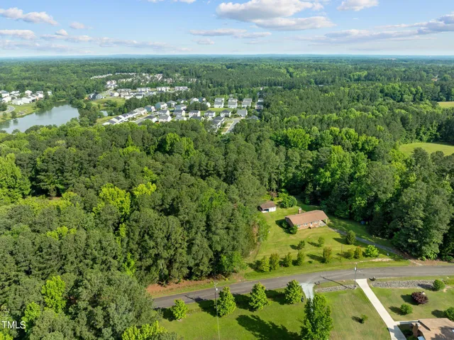 an aerial view of residential houses with outdoor space and trees
