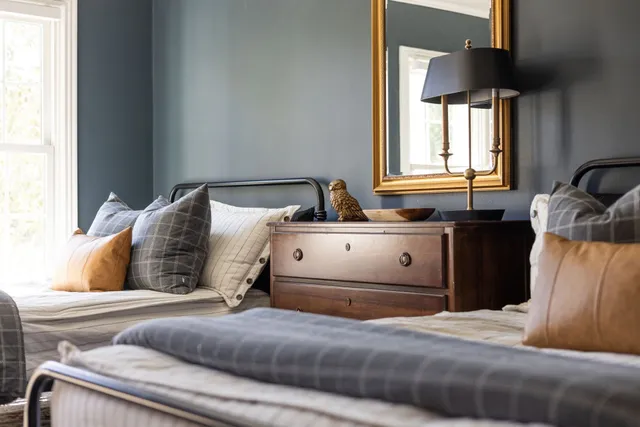 a spacious bedroom with two beds and painting on the wall
