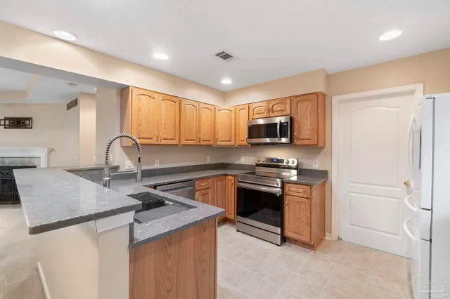 a kitchen with granite countertop a sink and stainless steel appliances