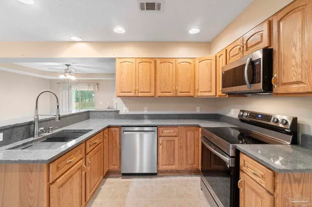 a kitchen with stainless steel appliances granite countertop a sink stove and cabinets