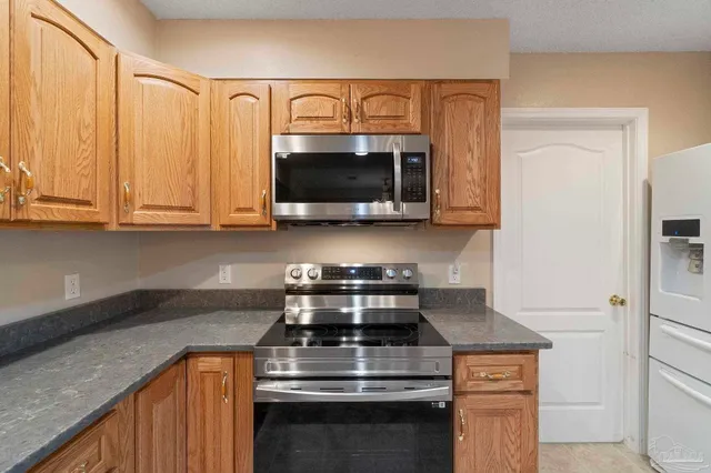 a kitchen with stainless steel appliances granite countertop a stove and a microwave