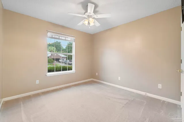 an empty room with a window and a fan