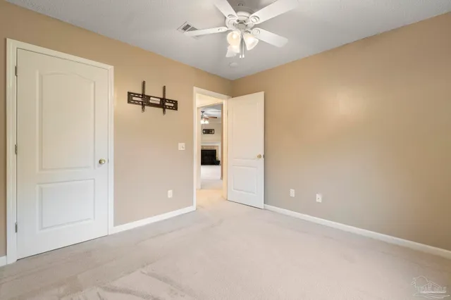 an empty room with closet and a chandelier fan
