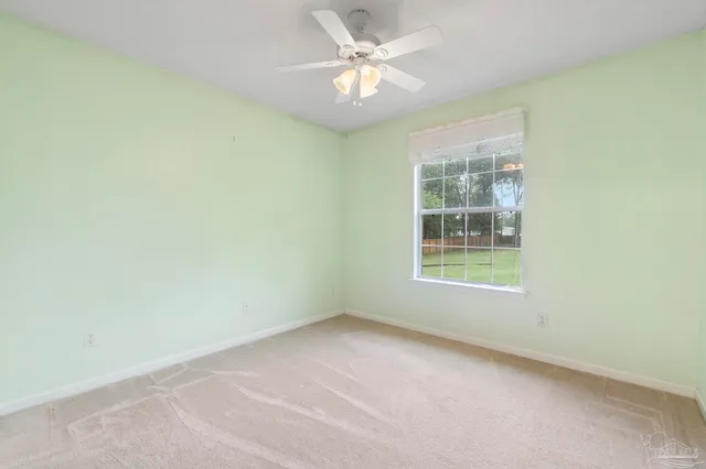 an empty room with a window and a fan