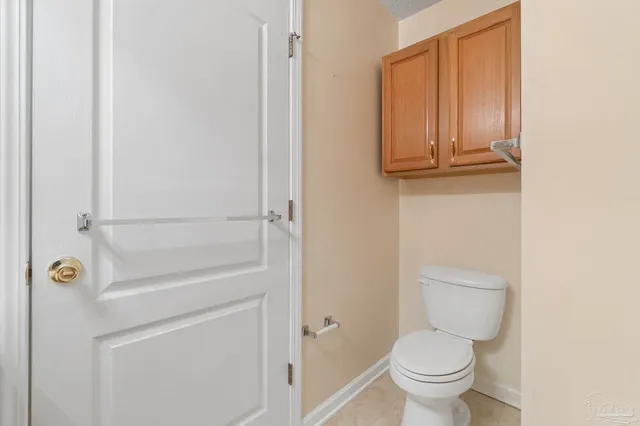 a bathroom with a granite countertop toilet and a sink