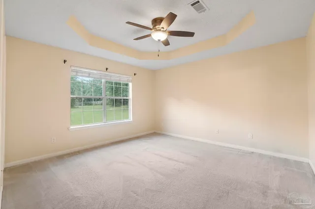 an empty room with a ceiling fan and window