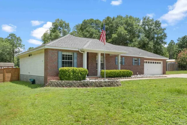 a view of a house with a yard and potted plants