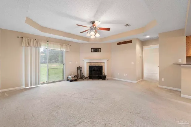an empty room with windows and fireplace