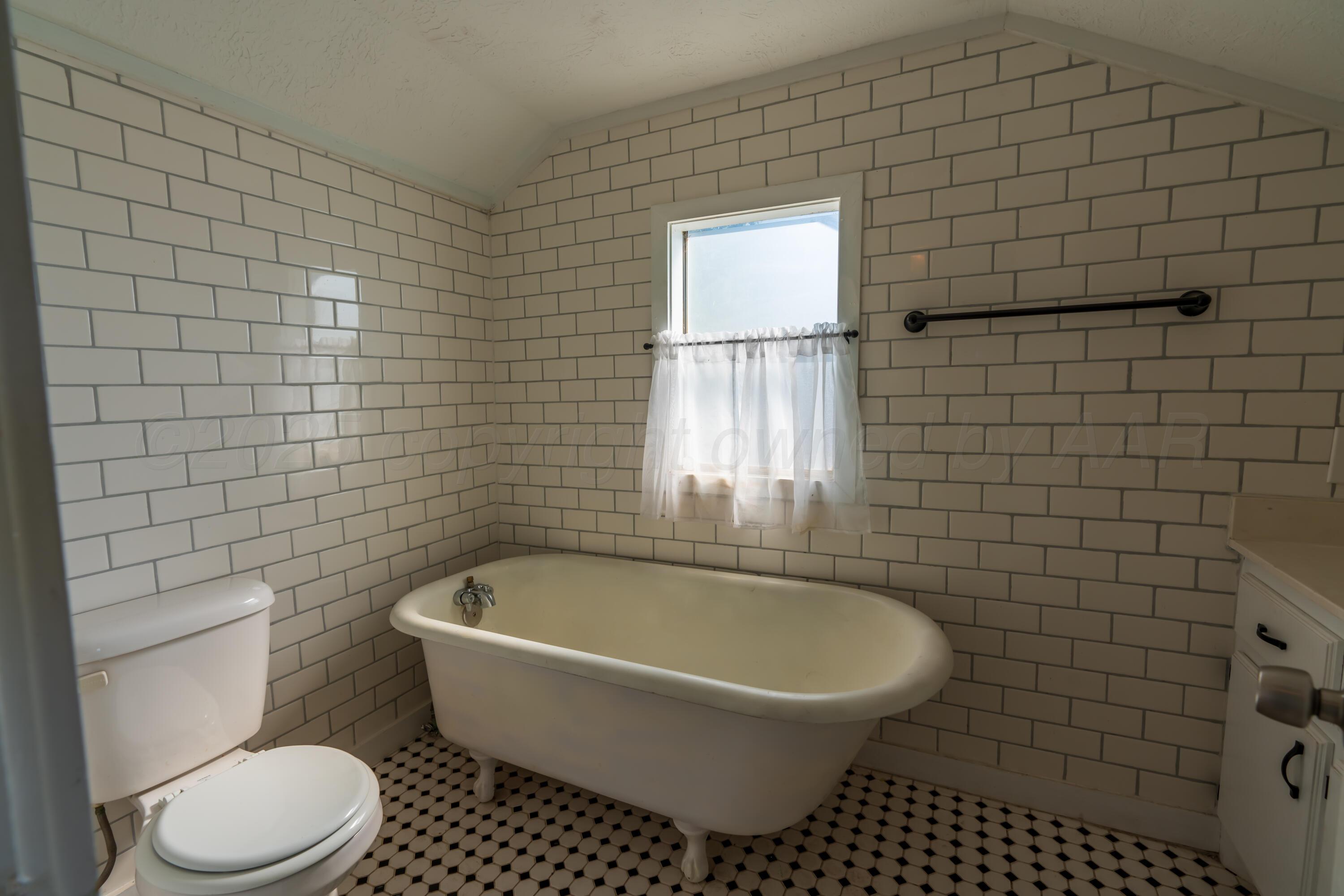 1220 Southwest 12th Avenue Amarillo, TX 79102 - Photo 17 of 25 a bathroom with a bathtub and toilet
