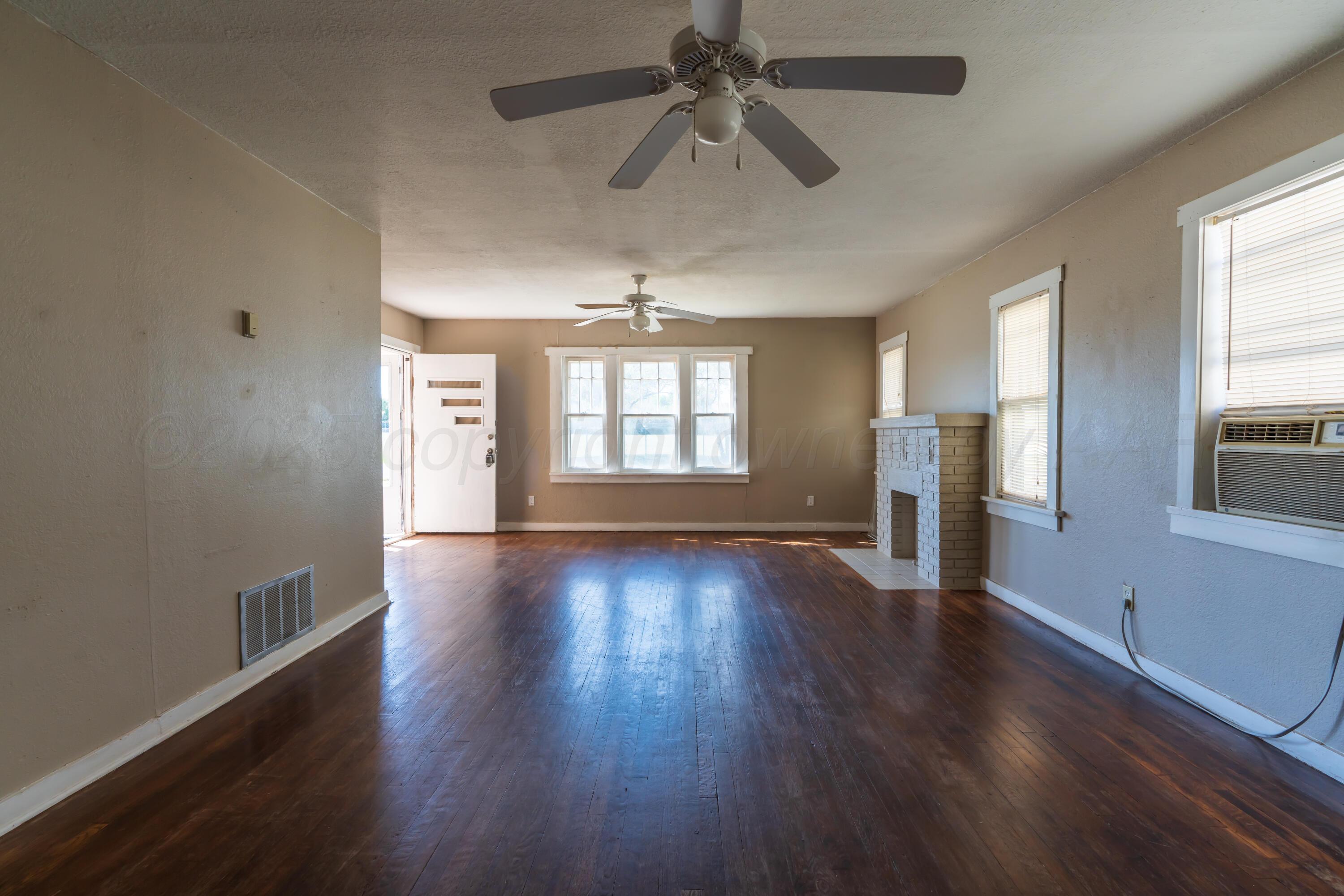 1220 Southwest 12th Avenue Amarillo, TX 79102 - Photo 7 of 25 an empty room with wooden floor and windows
