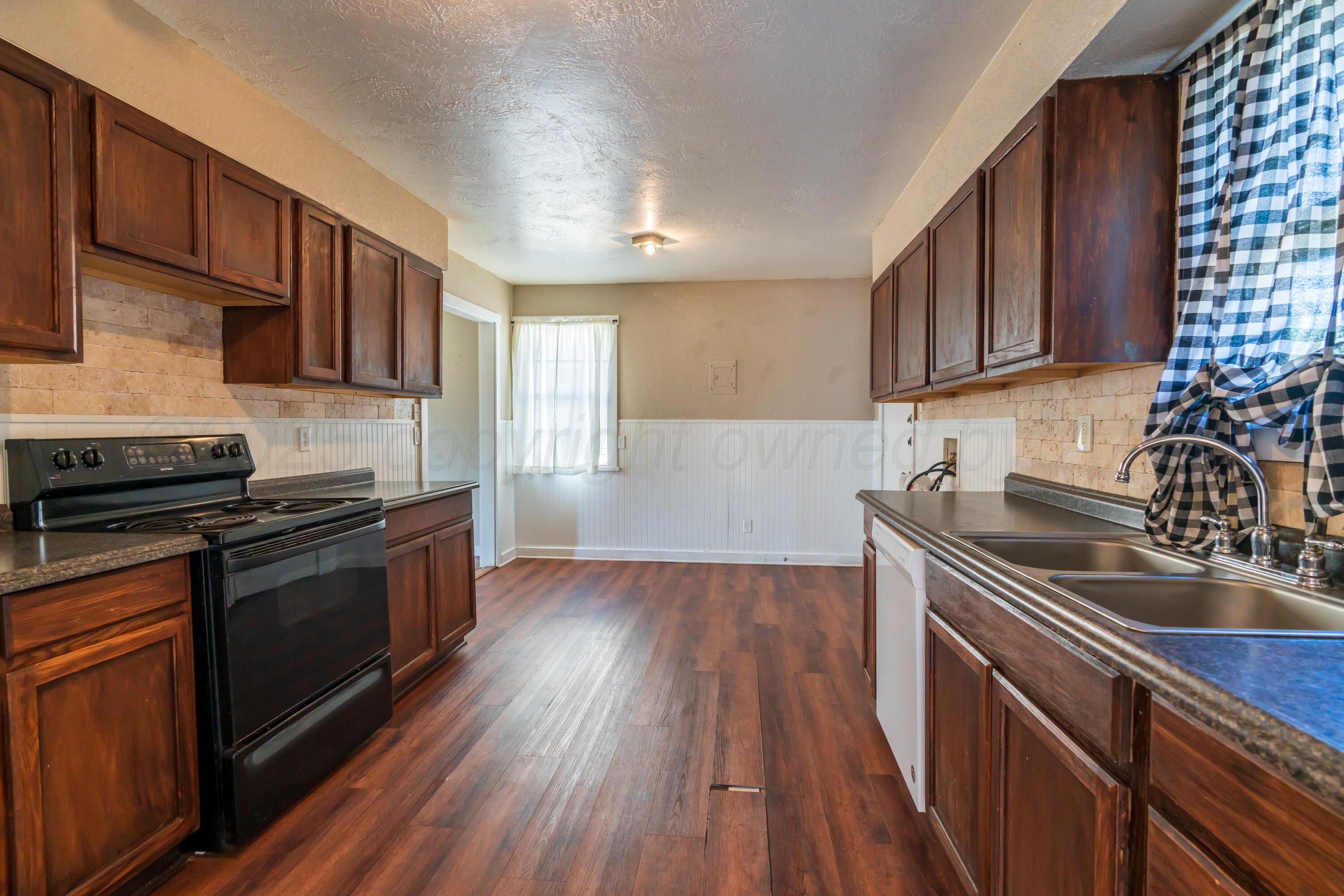 1220 Southwest 12th Avenue Amarillo, TX 79102 - Photo 9 of 25 a kitchen with a sink wooden floor and stainless steel appliances