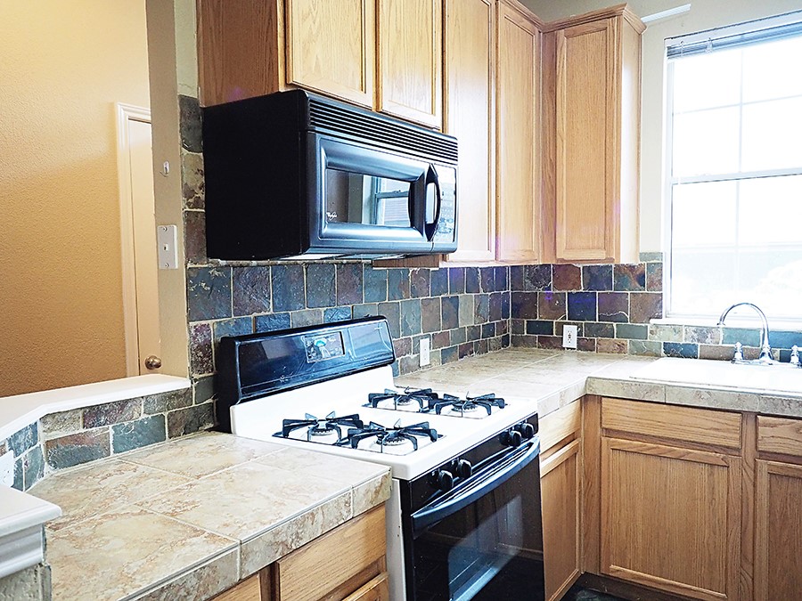 12401 Los Indios Trail, Unit 13 Austin, TX 78729 - Photo 16 of 27 a kitchen with a stove and a sink